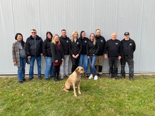 Mitarbeiterinnen und Mitarbeiter der qteck GmbH mit Bürohund Bashira